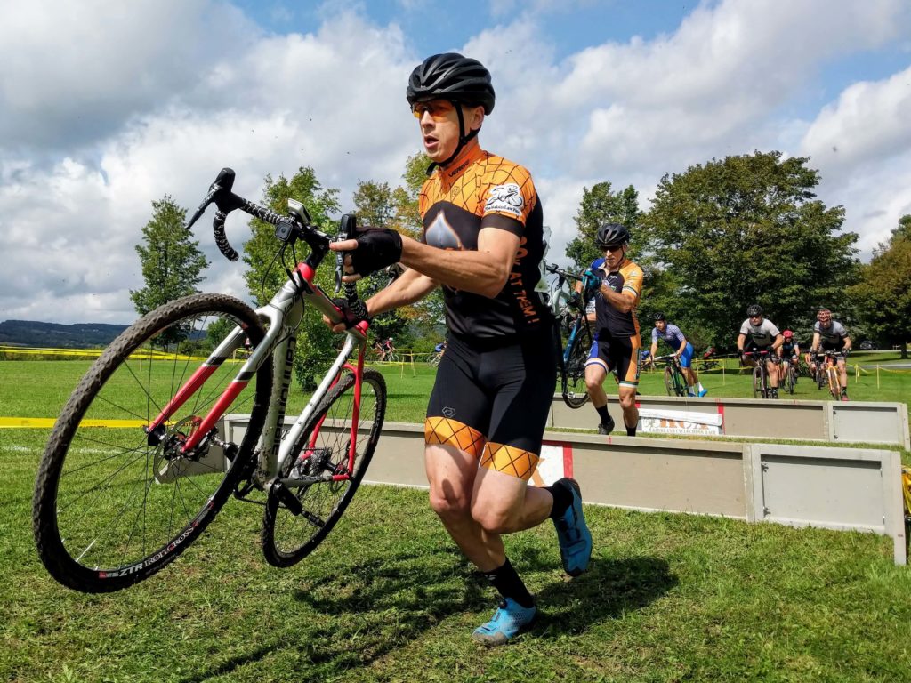 Scott Stewart dismounts and clears the cyclocross barriers